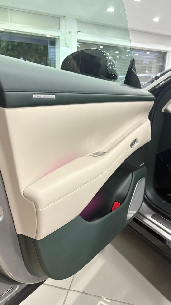Xiaomi YU7 Max — détail porte intérieure bi-tons sellier/vert, plaque Innovation For Everyone