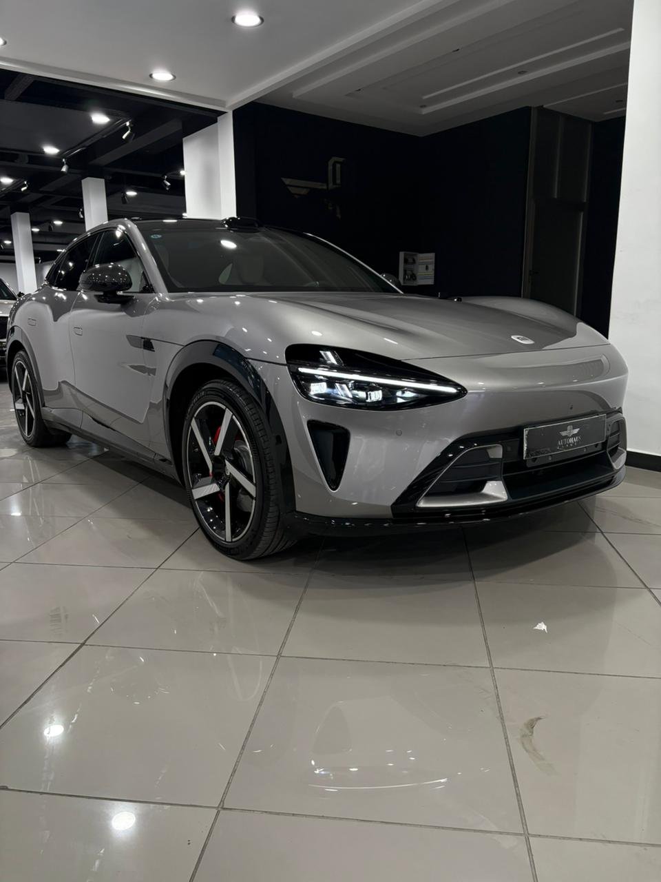 Xiaomi YU7 Max 2026 Gris Lunaire — 3/4 avant droit, signature LED pleine largeur, étrier Brembo rouge — premier exemplaire neuf au showroom Autohaus Tanger